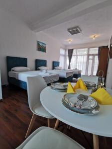a hotel room with two beds and a table and chairs at Konak II in Plav