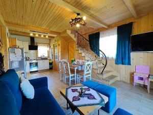 uma sala de estar com um sofá azul e uma cozinha em Domek u Śpiewoka 1 em Maruszyna