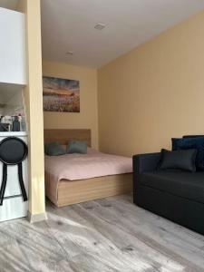 Un dormitorio con una cama y un sofá en una habitación. en Lāčplēšas ielas apartment 2, en Liepāja