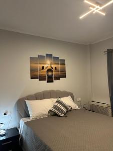 une chambre avec un lit avec trois tableaux au mur dans l'établissement Viktor's house by the sea, à Boukari