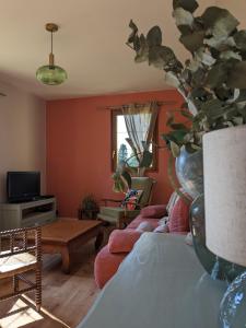 ein Wohnzimmer mit Sofa und Tisch in der Unterkunft L'orée du bois in Saint-Valery-sur-Somme