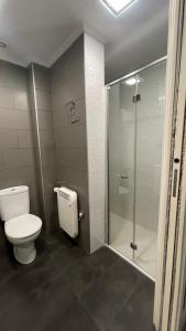 a bathroom with a toilet and a glass shower at Apartamento acogedor in Rentería +8 photos