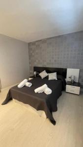 a bedroom with a black bed with two towels on it at Apartamento acogedor in Rentería