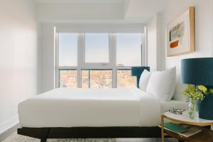 um quarto branco com uma cama grande e uma janela em Sonder at Artesa em Toronto