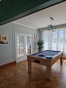 a pool table in a living room with a ceiling at Entre Terre et Mer in Plougoulm