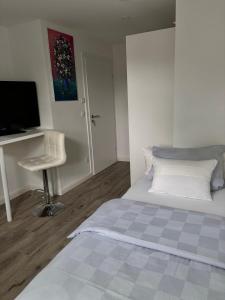 a bedroom with a bed and a desk and a chair at Zimmer mit Küche und Bad in Wedemark