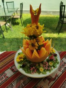 a fruit centerpiece on a plate with flowers on a table at Hotel San Blas in Lima
