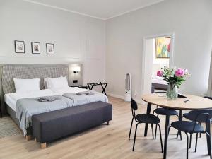 Un dormitorio con una cama y una mesa con sillas. en Anny 5 Apartamenty, en Cracovia