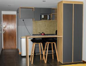 una cocina con 2 taburetes de barra en Home Rosario, en Rosario