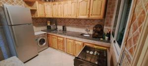 a small kitchen with wooden cabinets and a refrigerator at Appartement 2 chambres centre ville in Tetouan