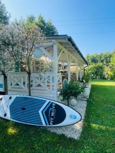 ein Surfbrett auf dem Gras vor einem Haus in der Unterkunft Domek holenderski Hampton in Dominice