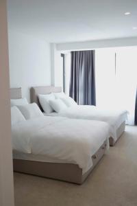 uma fila de camas brancas num quarto em CASA V Deluxe Queen Rooms em Kiseljak
