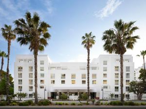un edificio bianco con palme di fronte di Sandbourne Santa Monica, Autograph Collection a Los Angeles