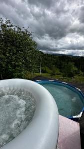a bath tub sitting next to a swimming pool at Казковий дім in Slavske