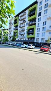 a street with cars parked in front of a building at Cozy Apartment Prima Nufărul in Oradea