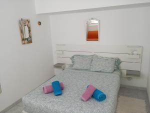 a bedroom with a bed with blue and pink pillows at Apto Magec in Puerto de Santiago