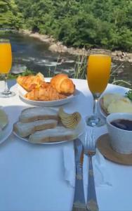 a table with a plate of food and glasses of orange juice at Machakhela cottage in Batumi +19 photos