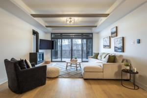 a living room with a couch and a tv at Tremblant Prestige - Verbier 4-102 in Mont-Tremblant +30 photos
