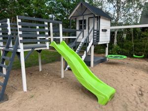 a playground with a slide and a play house at Green House Relax in Płaska