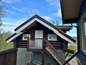 a log cabin with a porch and a balcony at Unique Arctic Timber Cabin in Skaidi