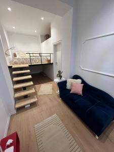 un soggiorno con divano blu e letto a soppalco di Green Villa 2 a Vlorë