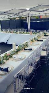 a long table with white tables and chairs at Pavillon bon enfant in Saint-Priest