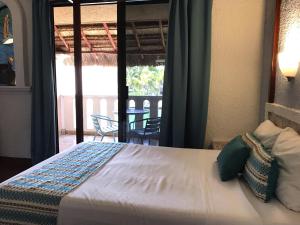 a bedroom with a bed with a view of a patio at Chez Waffle Hotel in Puerto Aventuras