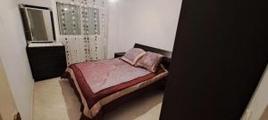 a small bedroom with a bed and a window at Appartement 2 chambres centre ville in Tetouan