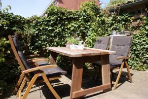 a wooden table and two chairs in a garden at Fenneluca, Den Hoorn in Den Hoorn