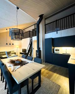 a dining room with a table and a kitchen at Skaidi Luxury Lodge – Heart of the Arctic in Hammerfest
