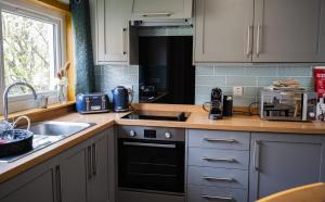 eine Küche mit Spüle und Herd oberen Backofen in der Unterkunft Luxury North Coast 500 Cottage by Helmsdale, stunning sea views in Portgower + 14 Fotos