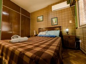 a bedroom with a bed with a checkered blanket at Rodex Hostel Tucuman in San Miguel de Tucumán