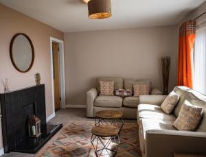 ein Wohnzimmer mit Couch und Kamin in der Unterkunft Luxury North Coast 500 Cottage by Helmsdale, stunning sea views in Portgower