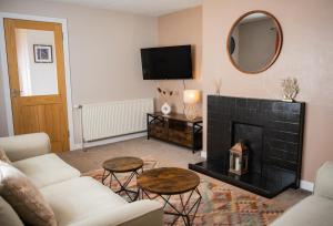 ein Wohnzimmer mit Kamin und Spiegel in der Unterkunft Luxury North Coast 500 Cottage by Helmsdale, stunning sea views in Portgower