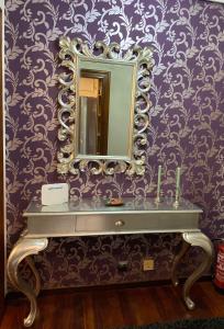 Baño con espejo en una pared púrpura en Apartamento El Rincón de Pilar en El Astillero