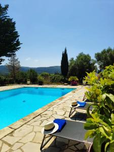 uma piscina com duas espreguiçadeiras ao lado em Logement La Belle Provence em Le Beausset