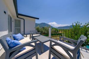 d'une terrasse avec 2 chaises et une table avec des oreillers bleus. dans l'établissement Green Hills Luxury Villa Fethiye, Yesiluzumlu by Sunworld Villas, à Fethiye