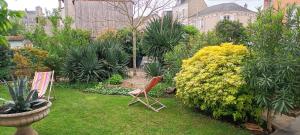 a garden with chairs and plants in a yard at agréables chambres d'hôtes près du centre ville avec jardin in Le Mans