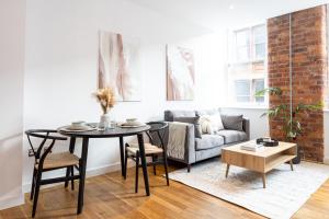 a living room with a table and a couch at Boutique City Centre Apartment in Manchester