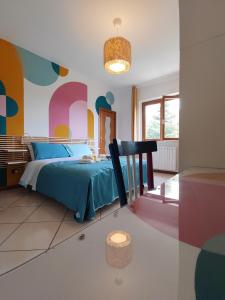 a bedroom with a blue bed and a colorful wall at Lully&Jeky -Casa vacanze- in Recanati +22 photos