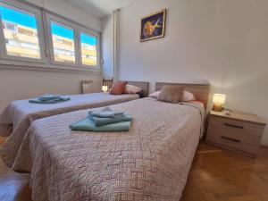 une chambre avec deux lits avec des serviettes dessus dans l'établissement Apartment Mangus, à Split 27 autres photos