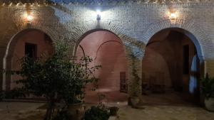 a room with a brick wall and three arches at Maison d'hôtes "Dar Khalifa" in Tozeur