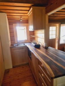 uma cozinha com armários de madeira e uma bancada em Blockhaus am See em Arvidsjaur