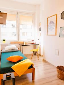 a bedroom with a bed with colorful pillows and a desk at Nocleg - Gdynia Śródmieście in Gdynia