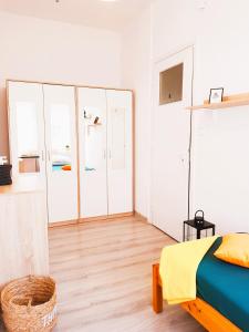 a white bedroom with a bed and a chair at Nocleg - Gdynia Śródmieście in Gdynia