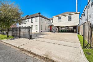 a house with a gate in front of a driveway at The Carriage House Retreat in Houston