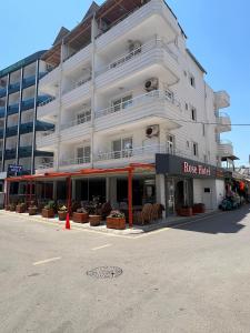 a large white building with a store on the street at Rose Hotel in Erdemli