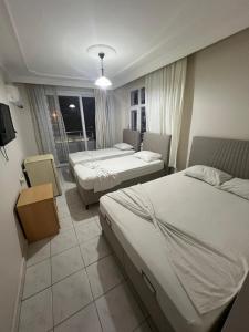a hotel room with two beds and a balcony at Rose Hotel in Erdemli