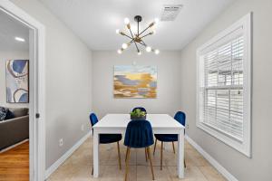 a dining room with a white table and blue chairs at The Carriage House Retreat in Houston