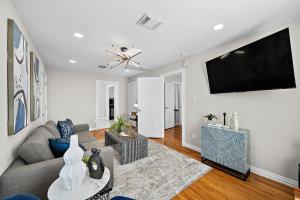 a living room with a couch and a flat screen tv at The Carriage House Retreat in Houston